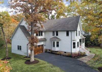 A white home with a driveway and trees.